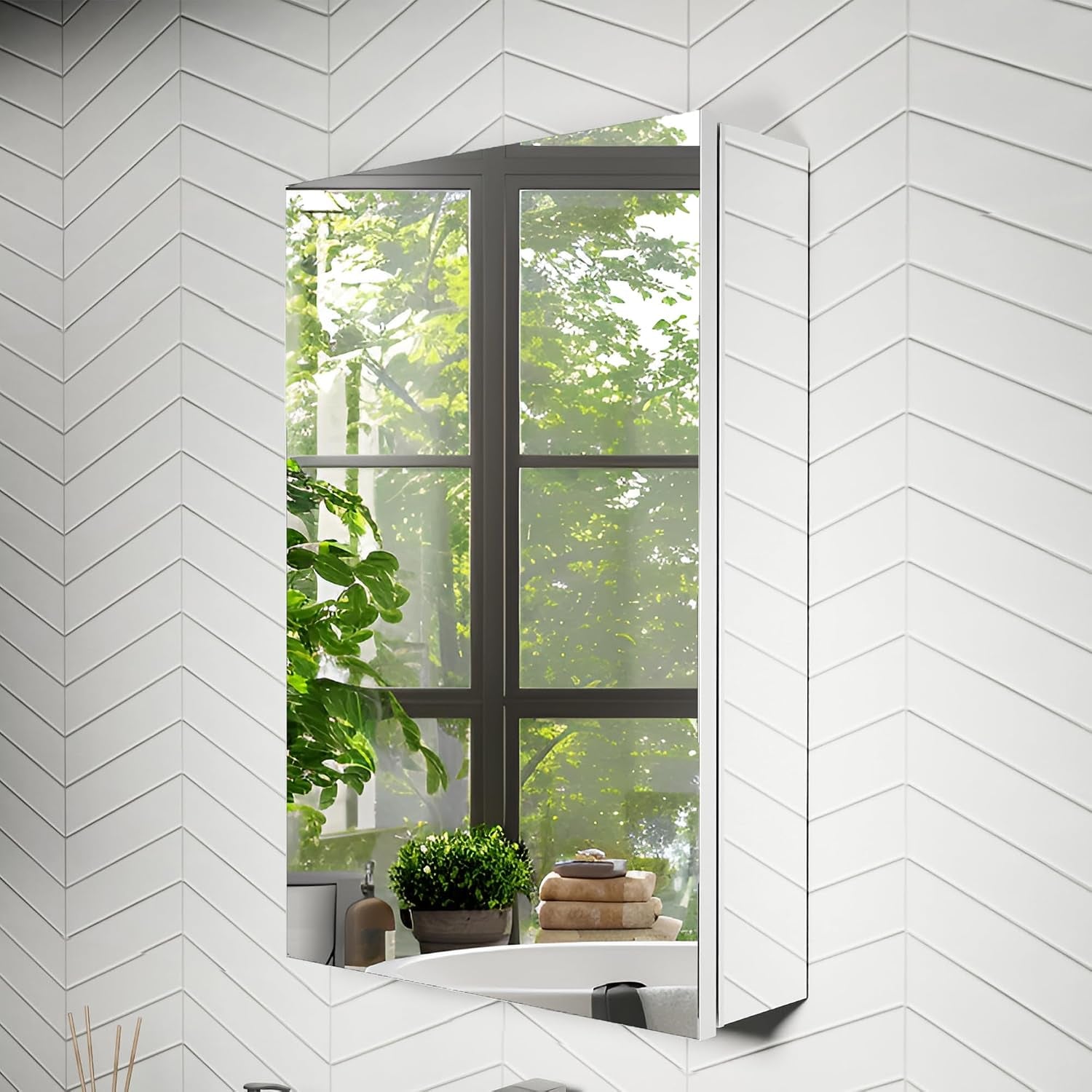 Recessed mirrored cabinet installed in a chevron-tiled bathroom corner reflecting greenery and a plant on a ledge