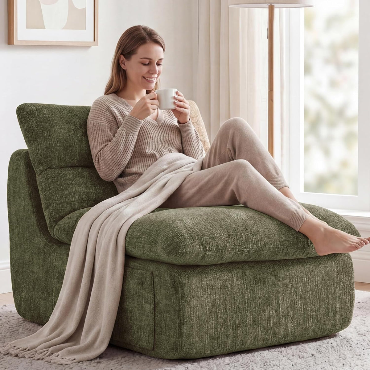Olive green chenille boneless floor chair angled front view with a woman reclining and a light throw blanket