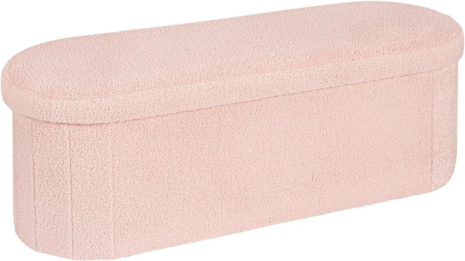 Long pale pink sherpa storage bench with soft rounded cushion top, front and left side visible