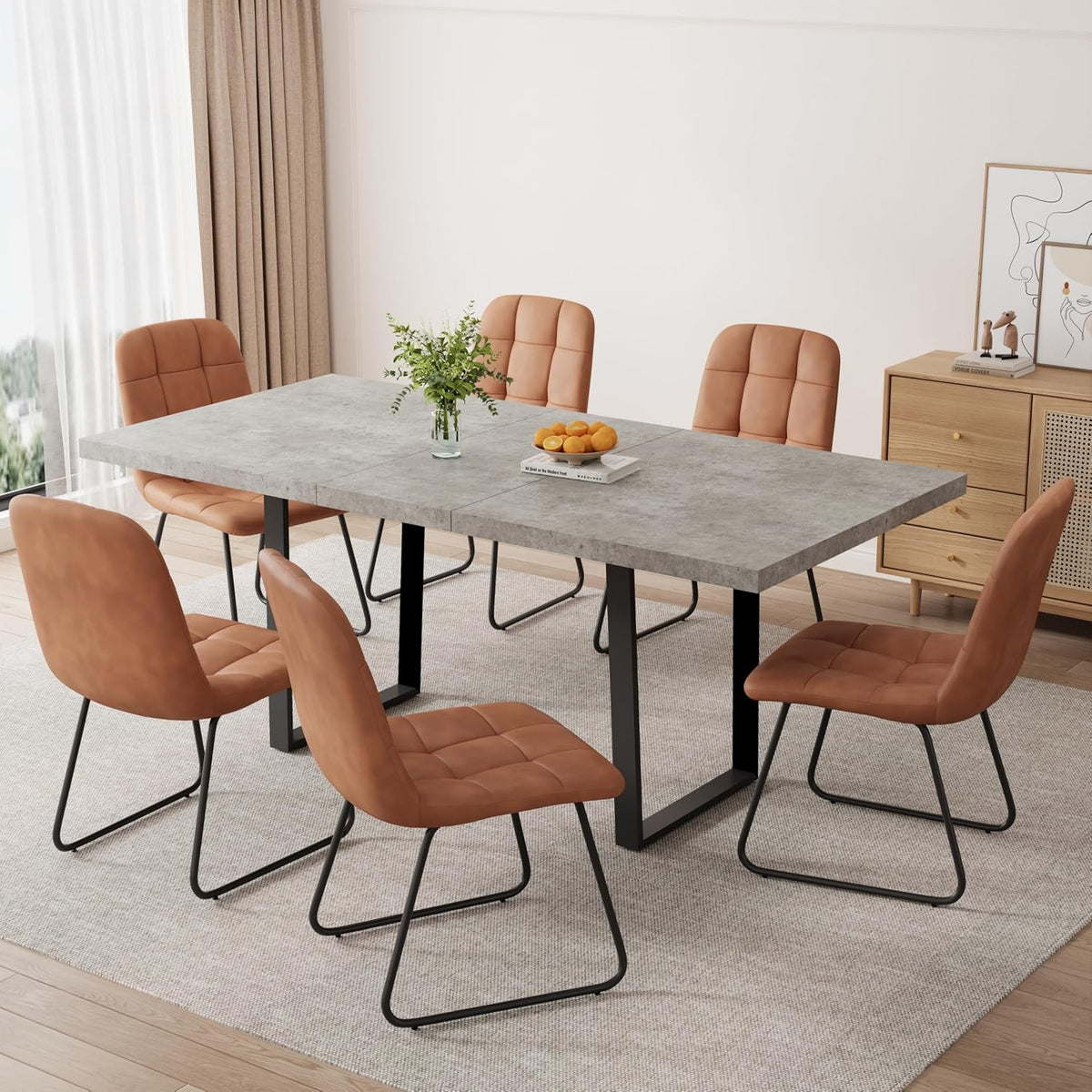 Expanded table with six tan leather-look chairs and U-shaped black metal legs in a bright dining space.