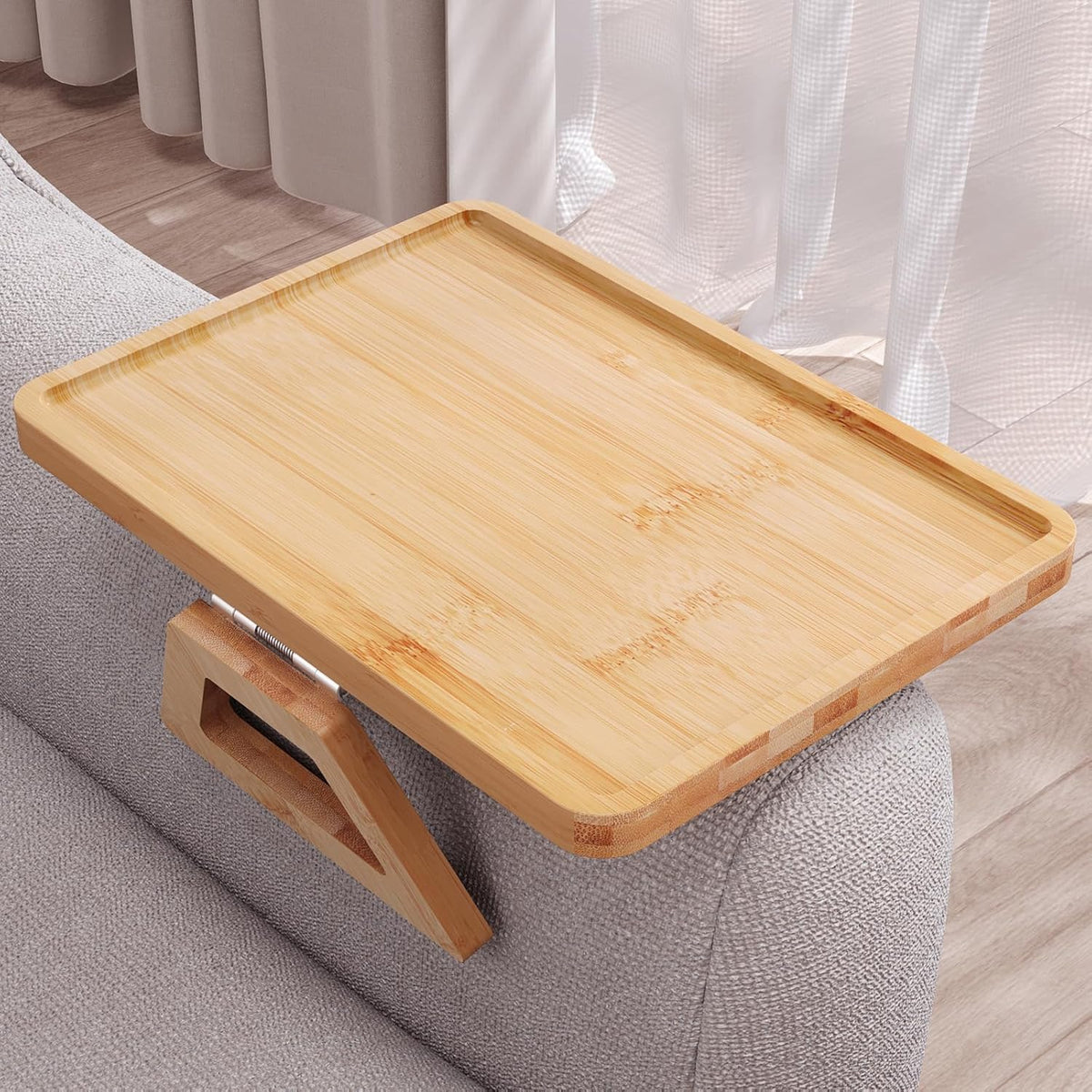 Close-up of the bamboo tray top surface on a sofa arm showing rounded edges and a shallow rim near a window