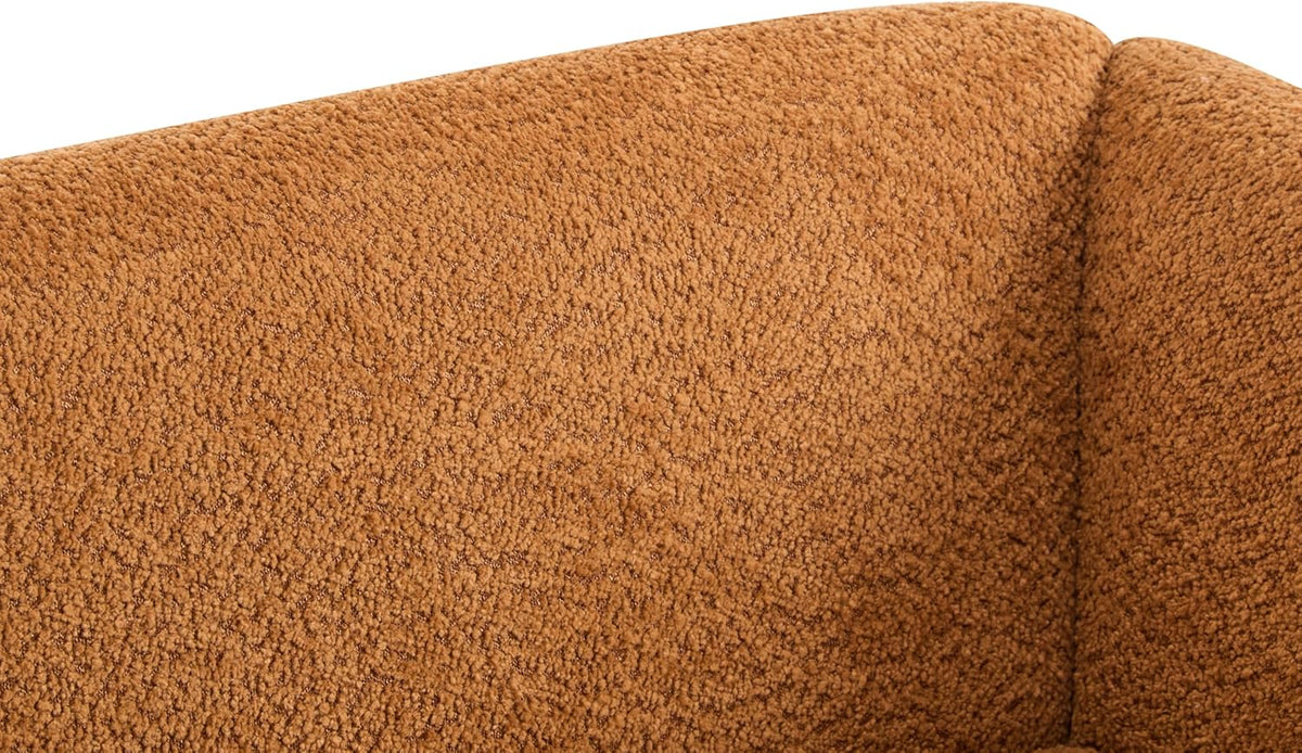 Close texture shot of the caramel-brown boucle upholstery on the sofa back and corner.