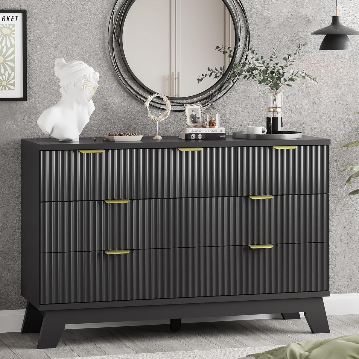 Black dresser top styled with a round mirror, bust sculpture, and decorative objects over ribbed drawers.