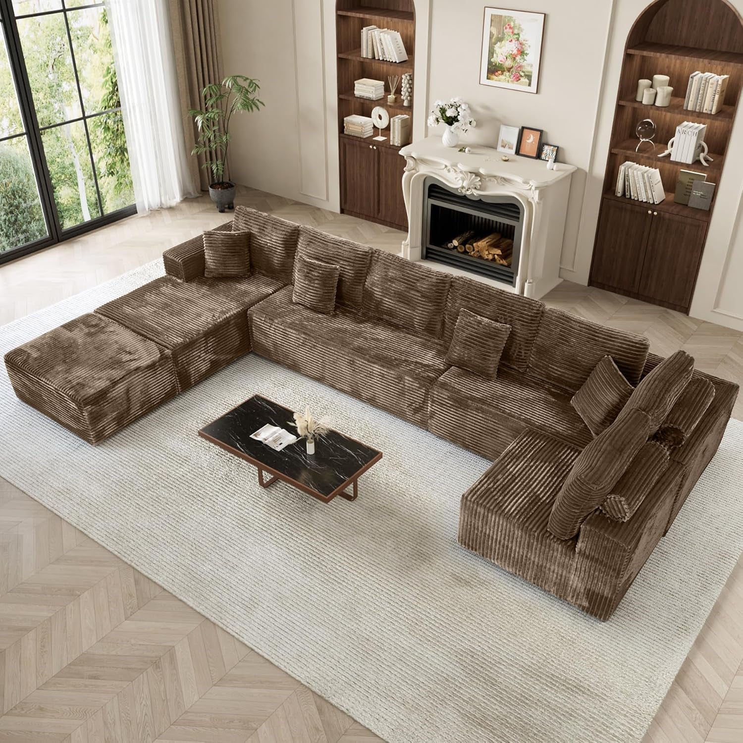 Top-down view of a brown L-shaped modular sectional arranged around a low coffee table on a pale rug.