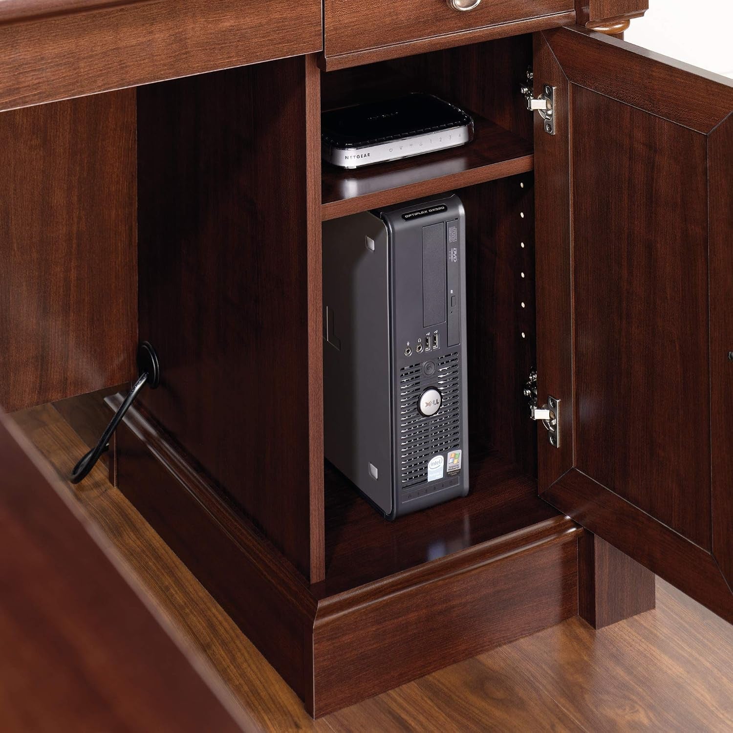 Close-up of desk cabinet in dark cherry with open door showing adjustable shelf and space for a vertical CPU tower
