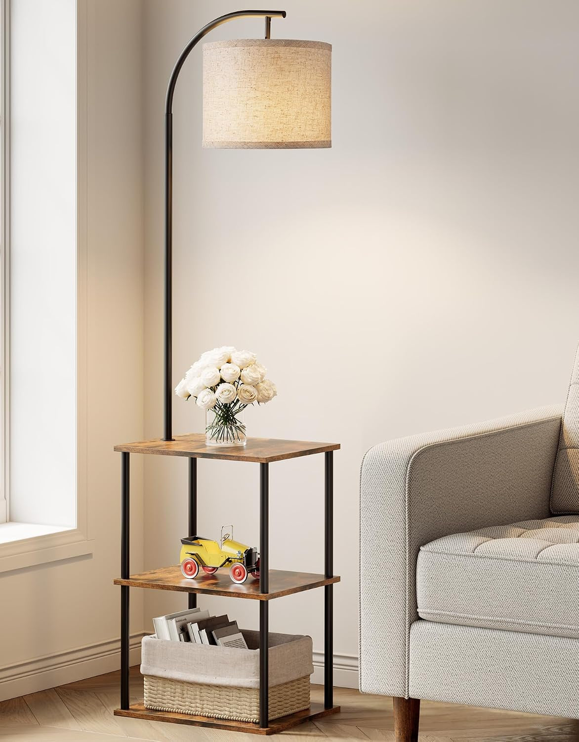 Arched floor lamp over three-tier wood side table beside a sofa in a neutral living room