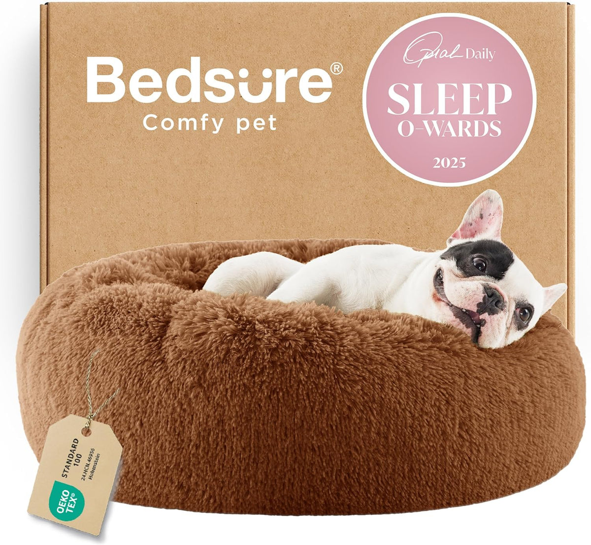 Brown round faux-fur donut pet bed in front of a cardboard box, a small white-and-black dog peeks over the rim.