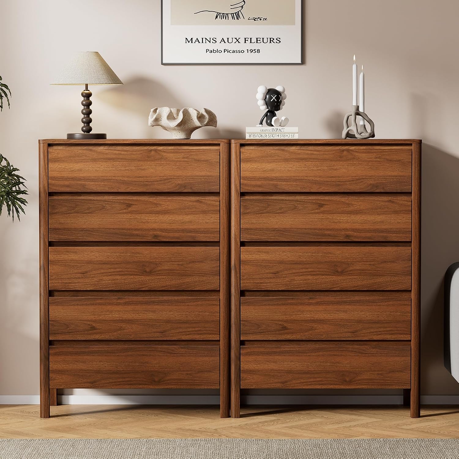 Two identical walnut dressers placed side by side with decor and wall art above