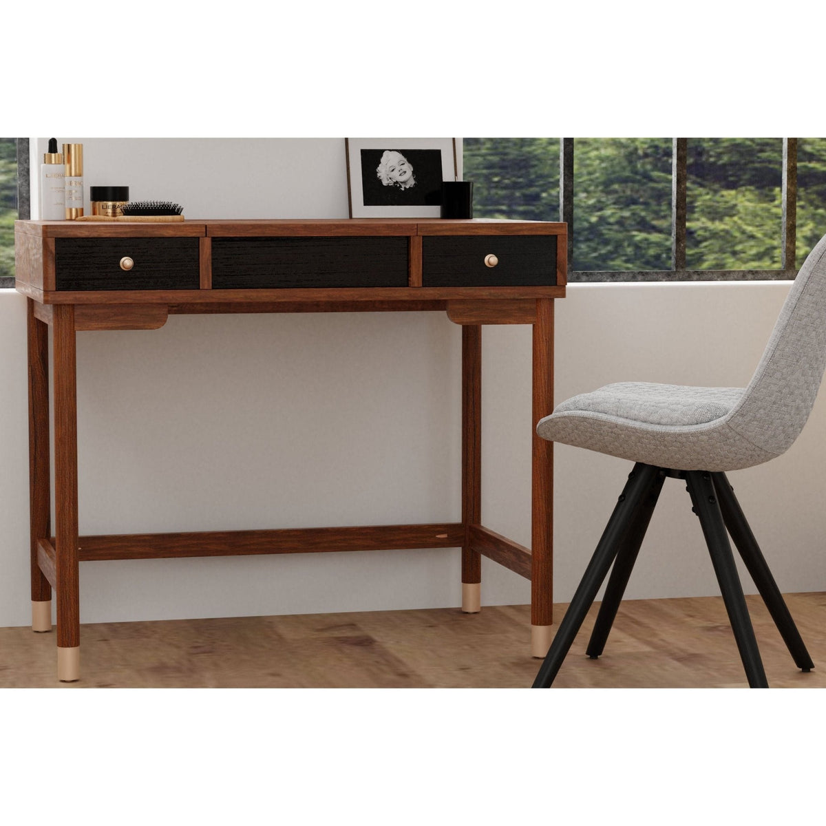 Two-tone walnut and black vanity desk shown closed beside a gray chair
