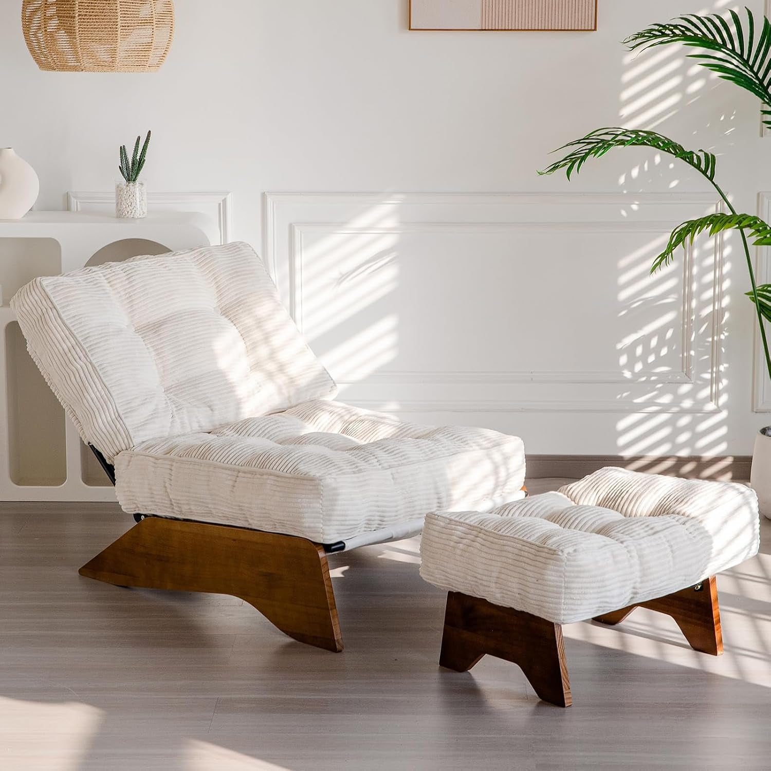 Beige corded fabric tufted accent chair with matching ottoman and wooden base angled front view in a living room