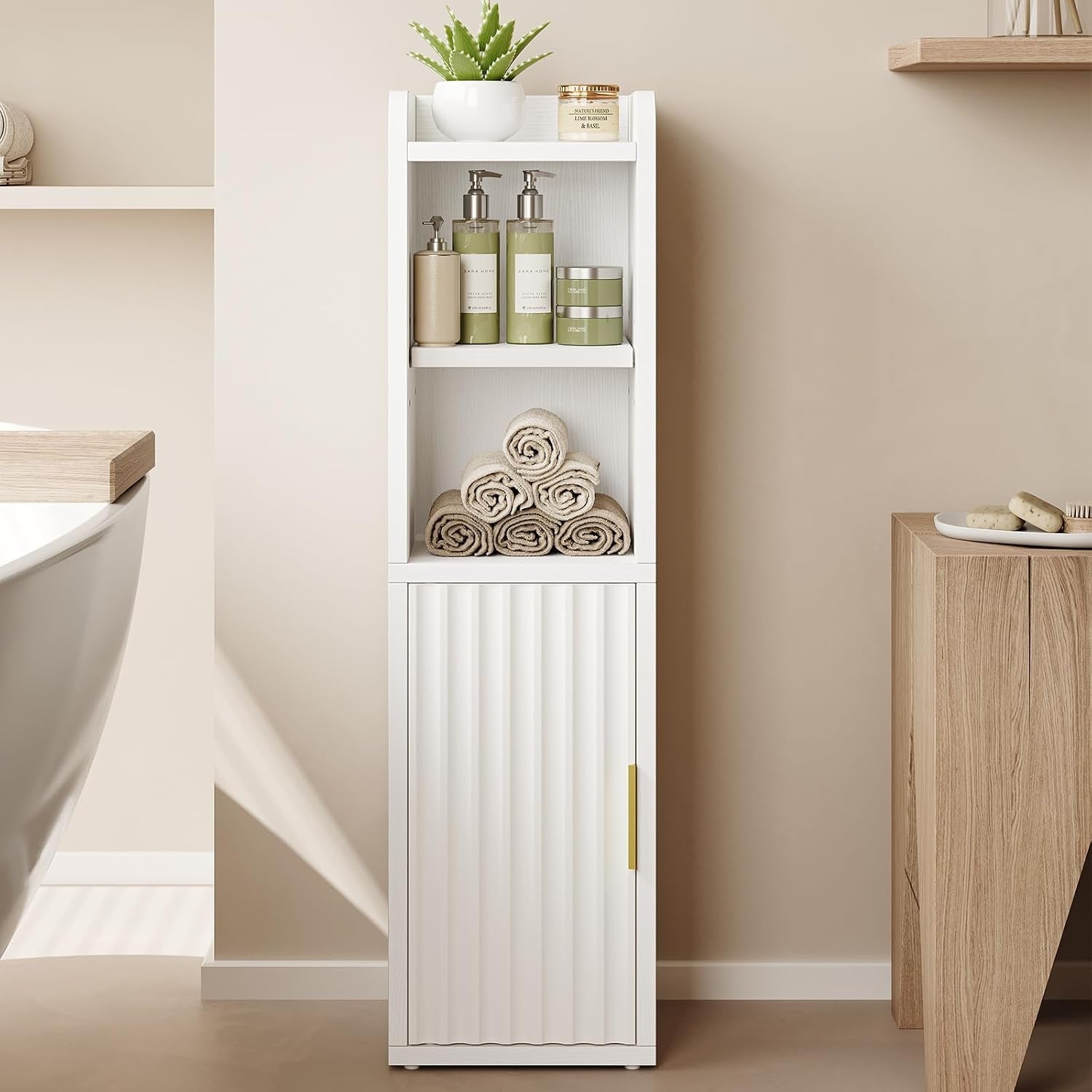 White freestanding bathroom cabinet centered view with rolled towels on the middle shelf and fluted door below
