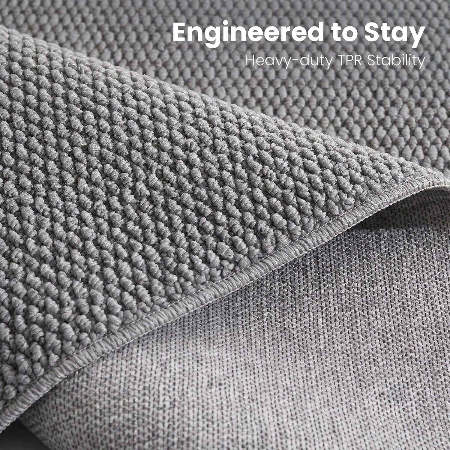 Close-up of the rug edge flipped to show woven grey jute-style texture and the fabric backing beneath.