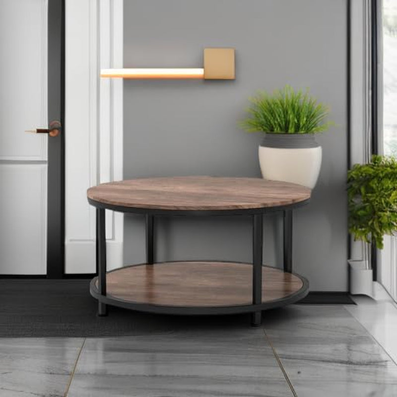 Round two-tier table placed in an entryway setting with plant and wall light nearby