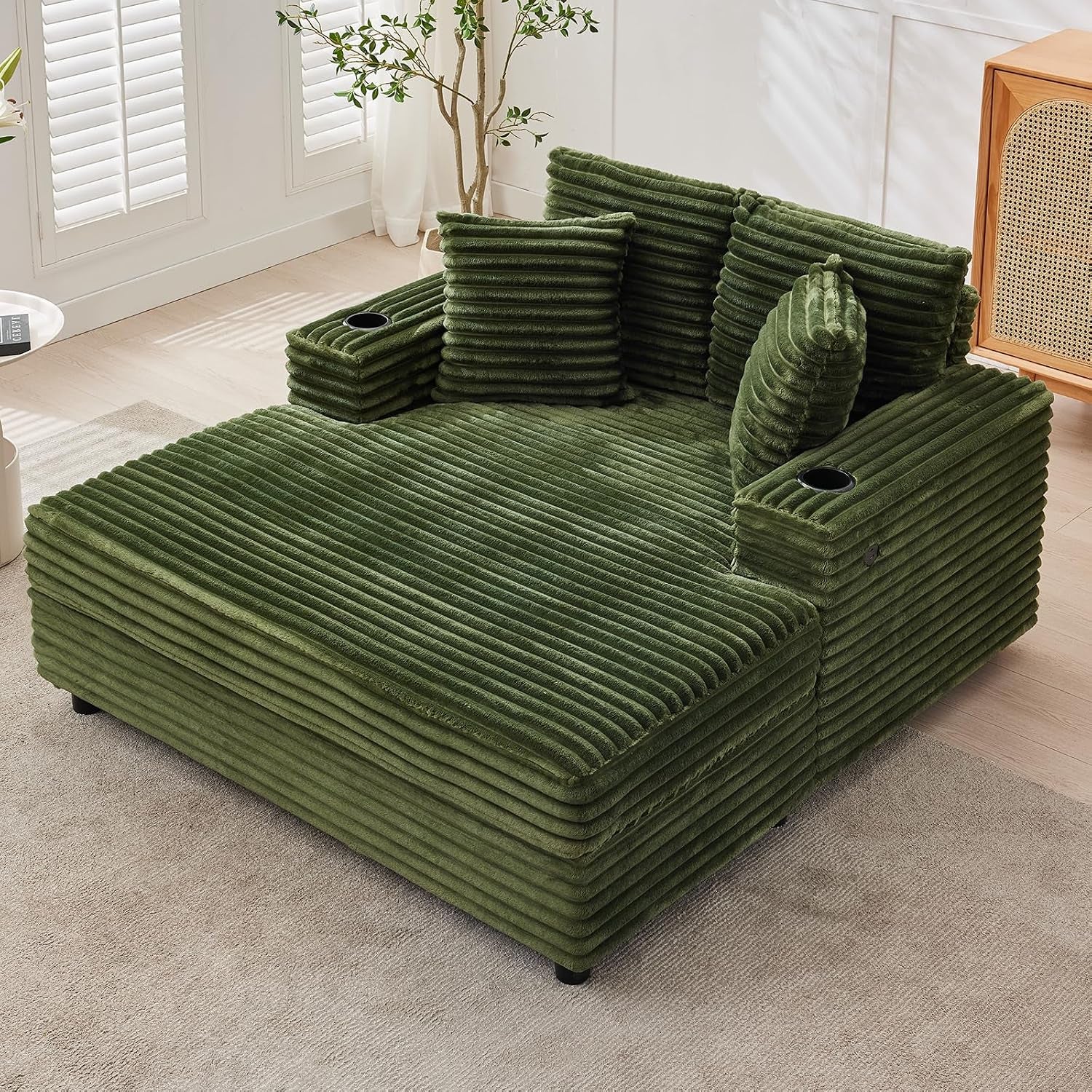 Deep green ribbed chaise lounge with cup holders and matching cushions on light flooring.