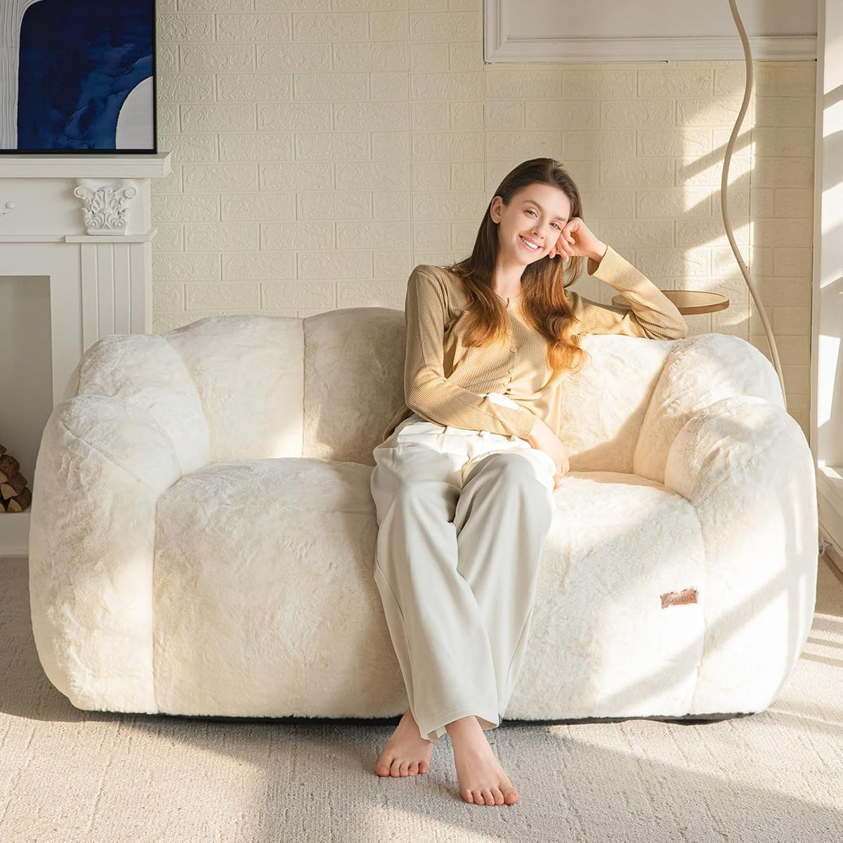 Beige floral-shaped faux fur loveseat with woman seated, front view in a sunlit living room