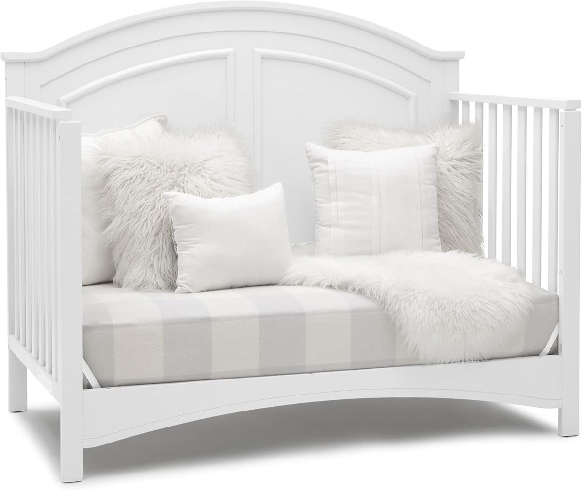 White daybed styled with fluffy and textured white pillows and a soft throw on the mattress