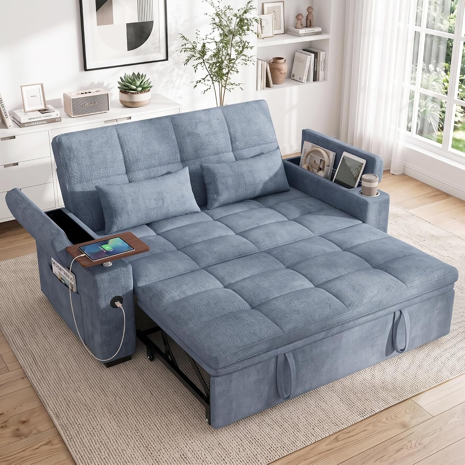 Blue chenille sleeper in same room, pulled out into bed with tufted surface and visible tablet tucked in side pocket