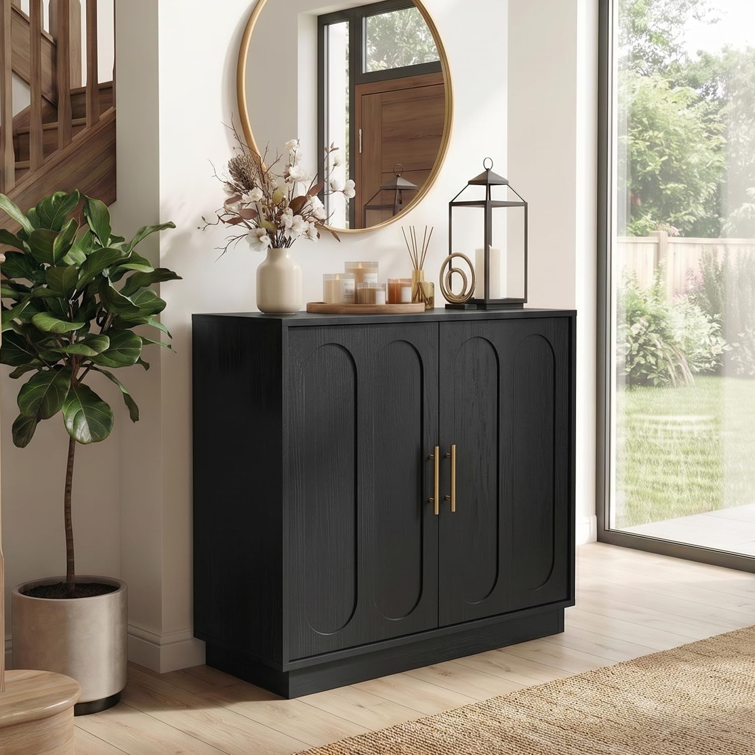 Angled view of a matte black three-door fluted cabinet with gold handles beside a staircase and large window.