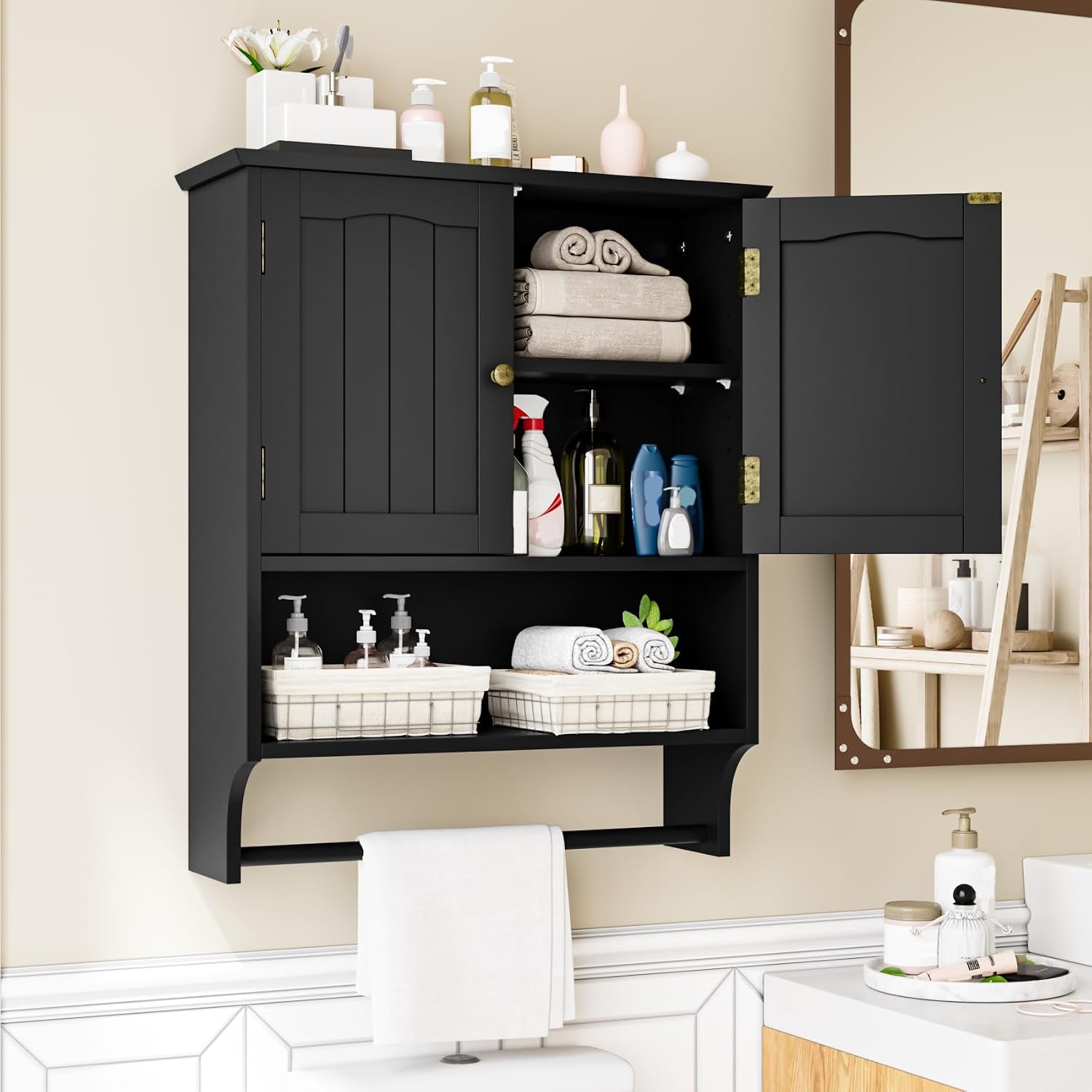 Black wall cabinet with one door open showing folded towels and toiletries, towel bar below.