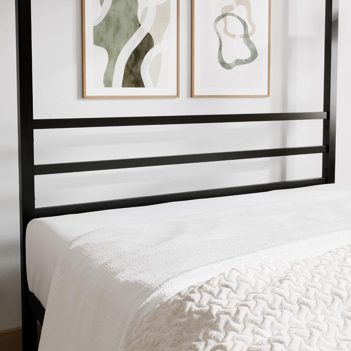 Close-up of black metal slatted headboard and horizontal frame rails against a white wall