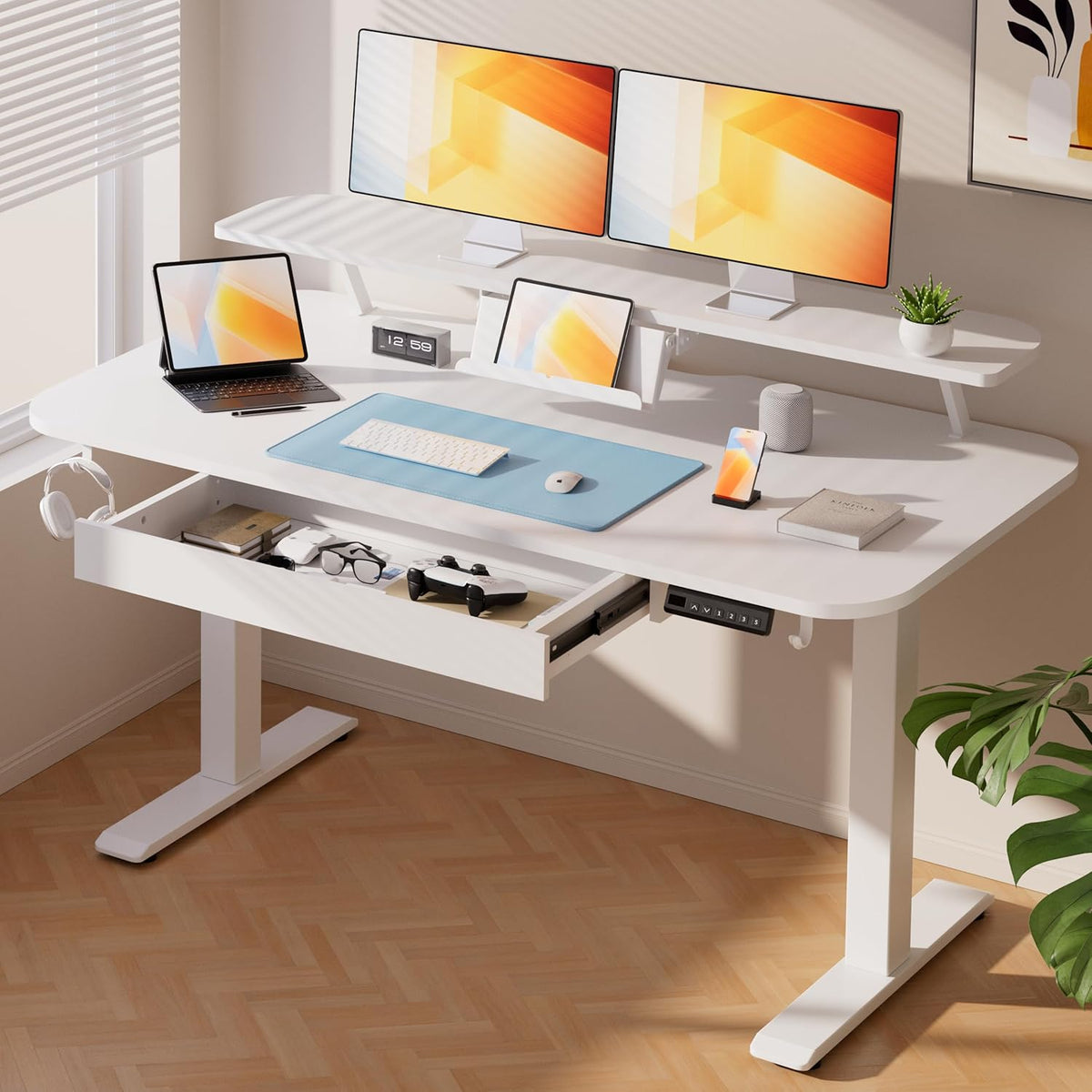 White standing desk with open pull-out drawer, adjustable monitor shelf, laptop stand and desk accessories on the surface