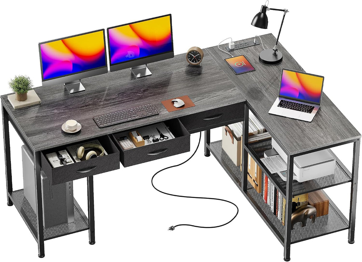Dark gray L-shaped desk with metal frame, open drawers and two-tier mesh shelving holding books and a printer.