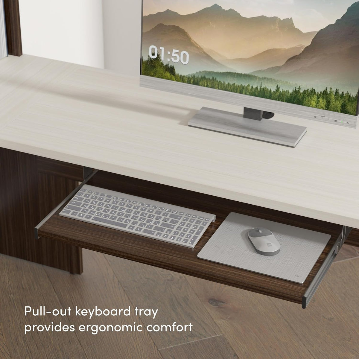 Light wood desk surface with a monitor and a pulled-out keyboard tray holding a keyboard and mouse pad.