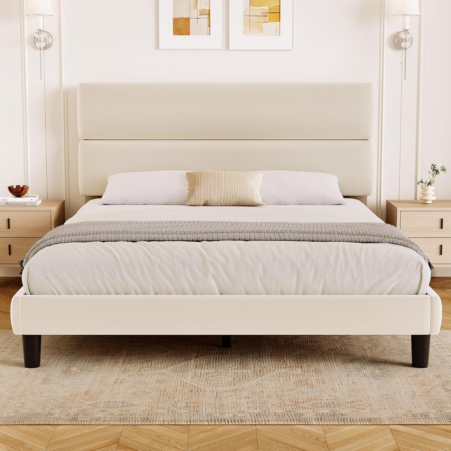 Front bedroom view of a cream upholstered platform bed with a tall two-panel headboard.