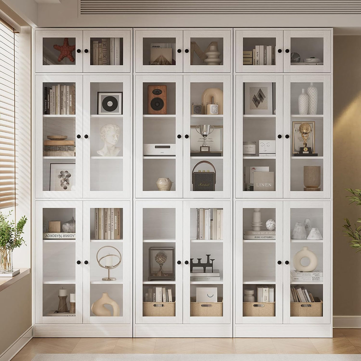 Three white glass-door bookcases arranged side by side as a storage wall