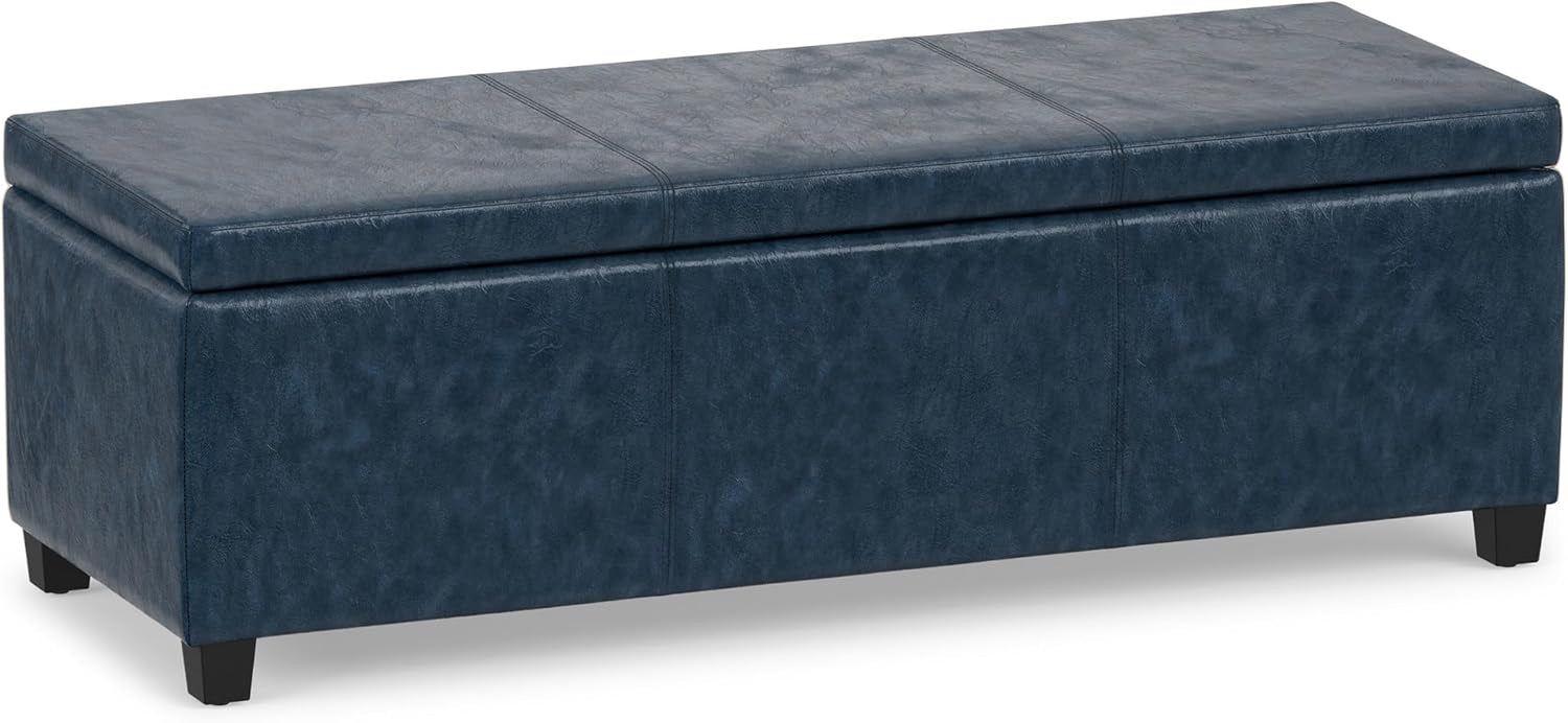 Three-quarter front view of a navy blue rectangular lift-top storage ottoman with subtle distressed texture.