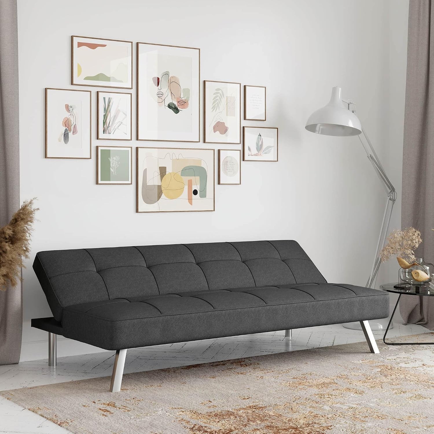 Charcoal sofa shown in lounger position in a bright living room with framed wall art and floor lamp