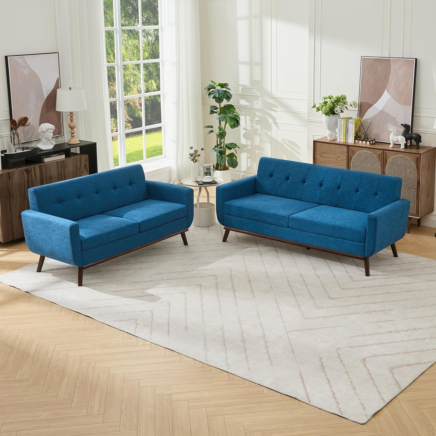 Bright living room with blue upholstered two-seat loveseat and three-seat sofa on light rug