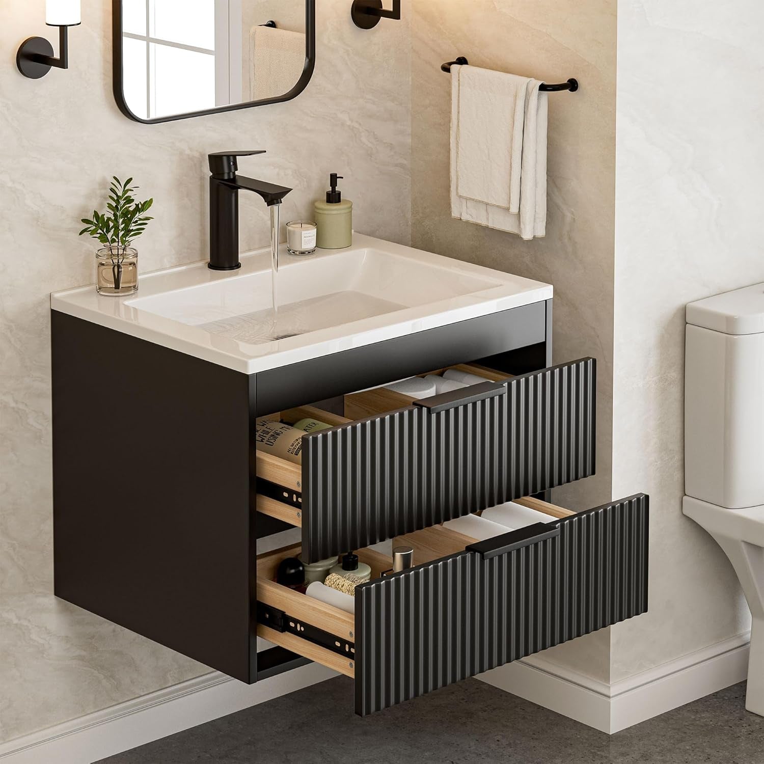 Black wall-mounted bathroom vanity with white resin sink and two drawers open, angled front view