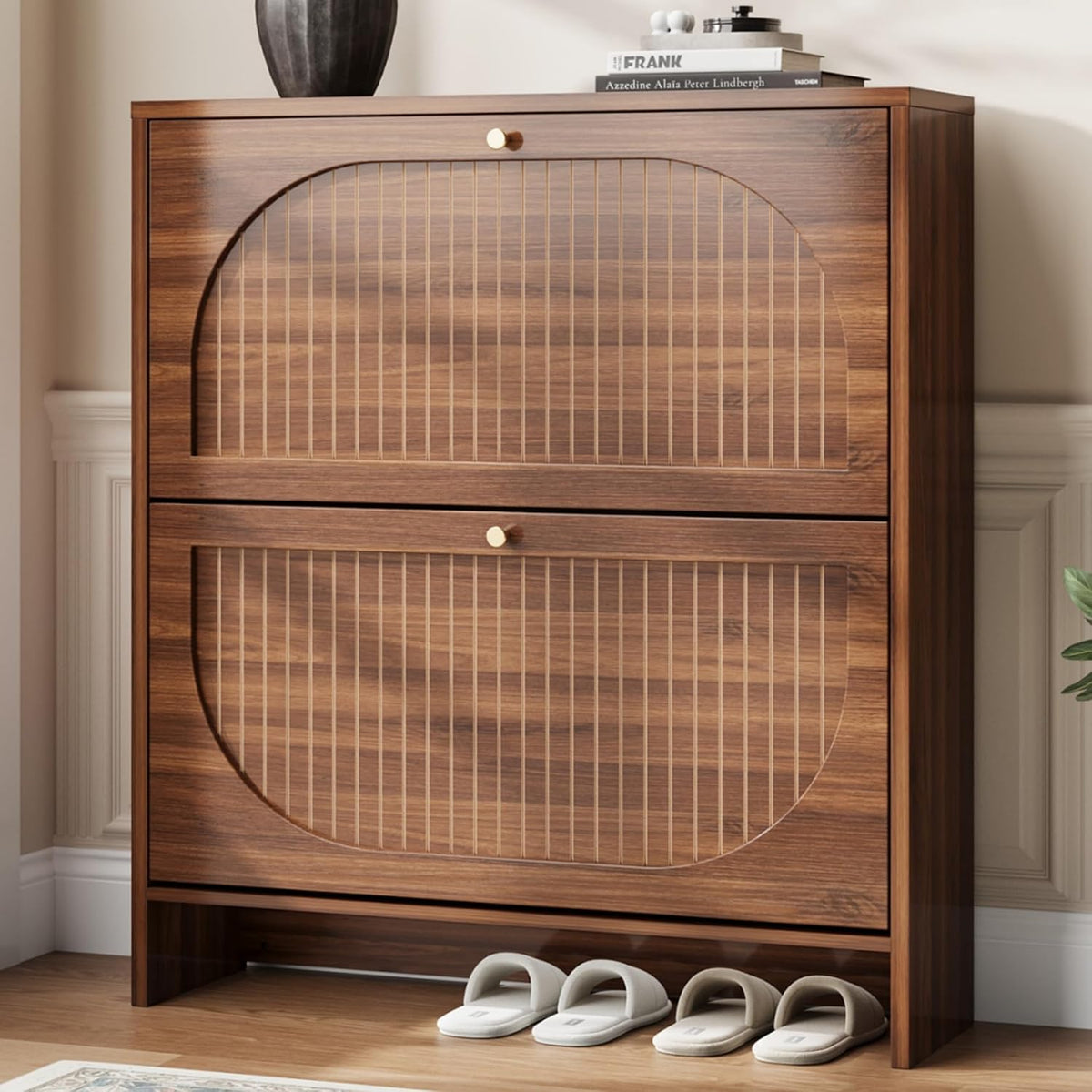 Three-quarter view of a dark wood shoe cabinet with two arched cane-front tilt drawers and slippers below