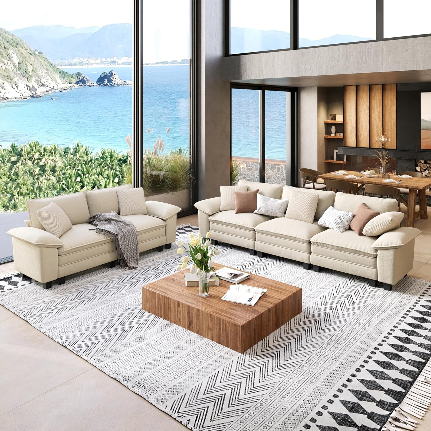 Bright living room with white chenille three-seat sofa and matching loveseat on patterned rug, low wood coffee table and