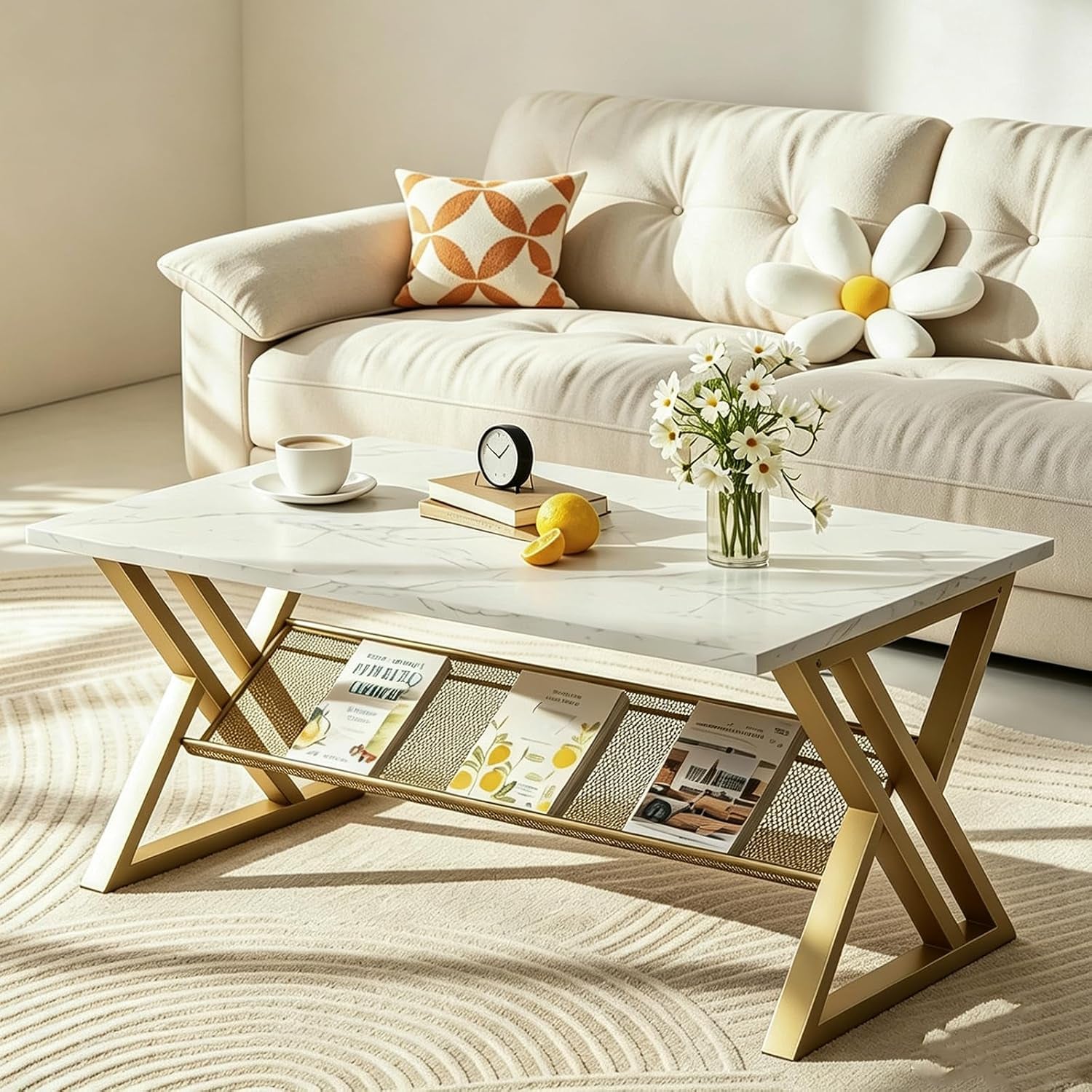 White faux‑marble top with gold X‑legs and a mesh magazine shelf underneath, staged by a cream sofa.