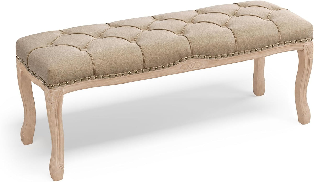 Angled view of a beige linen tufted bench with light unfinished wood frame and cabriole legs.