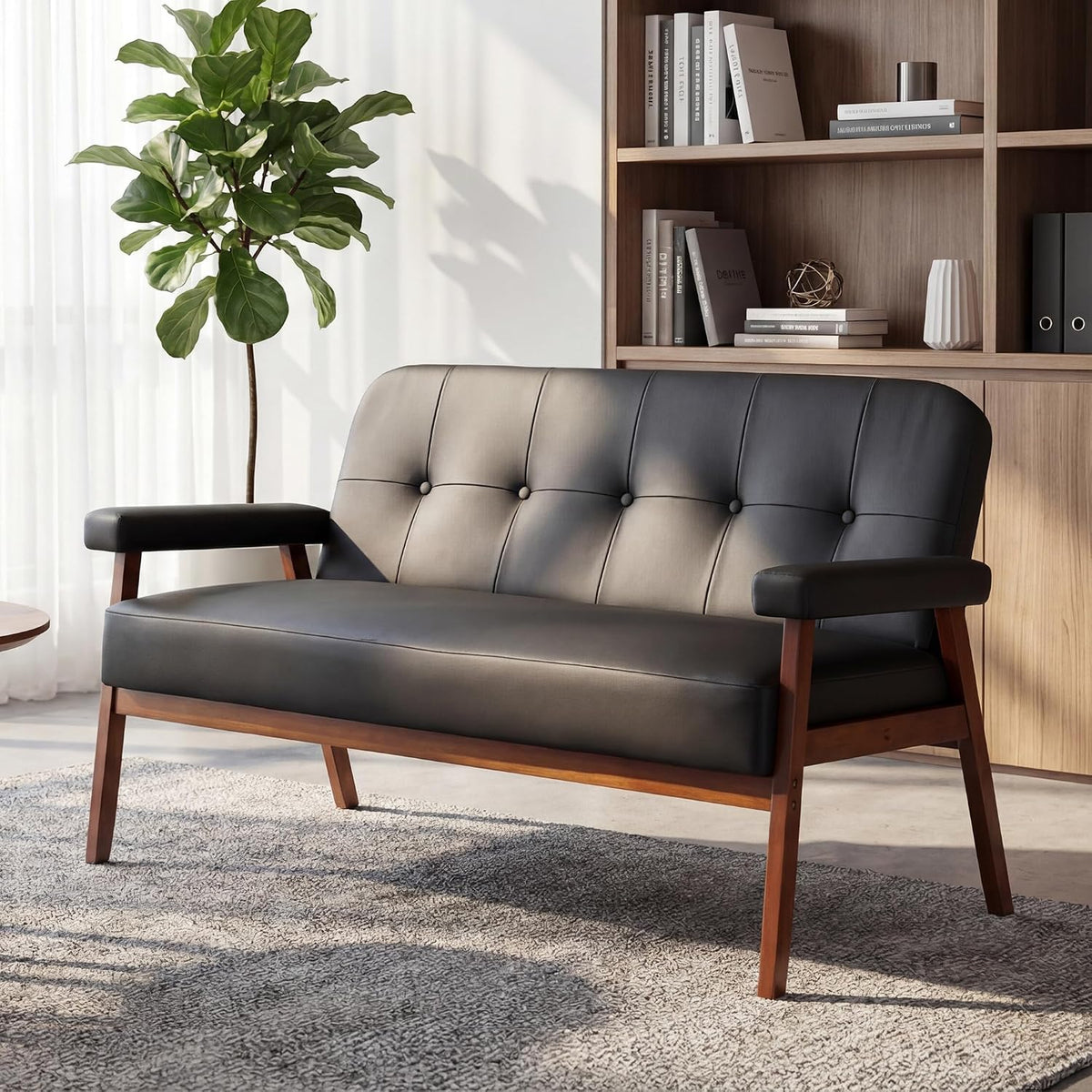 Black faux leather loveseat angled front view with tufted back and walnut-colored wood legs in a living room