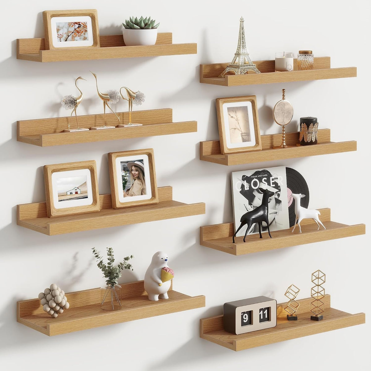 Angled view of staggered light‑wood ledges in two columns displaying small sculptures, framed photos and a vinyl record.