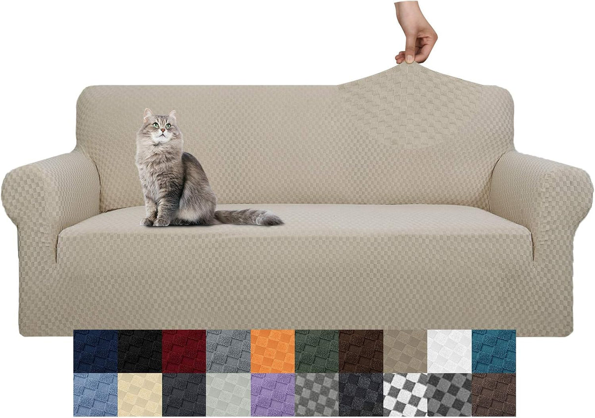 Three-seat sofa covered in tan textured slipcover with a gray cat seated on the cushion, hand stretching fabric on the back.