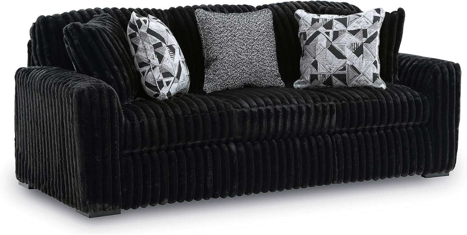 Front view of a black jumbo-corduroy oversized sofa with three throw pillows.