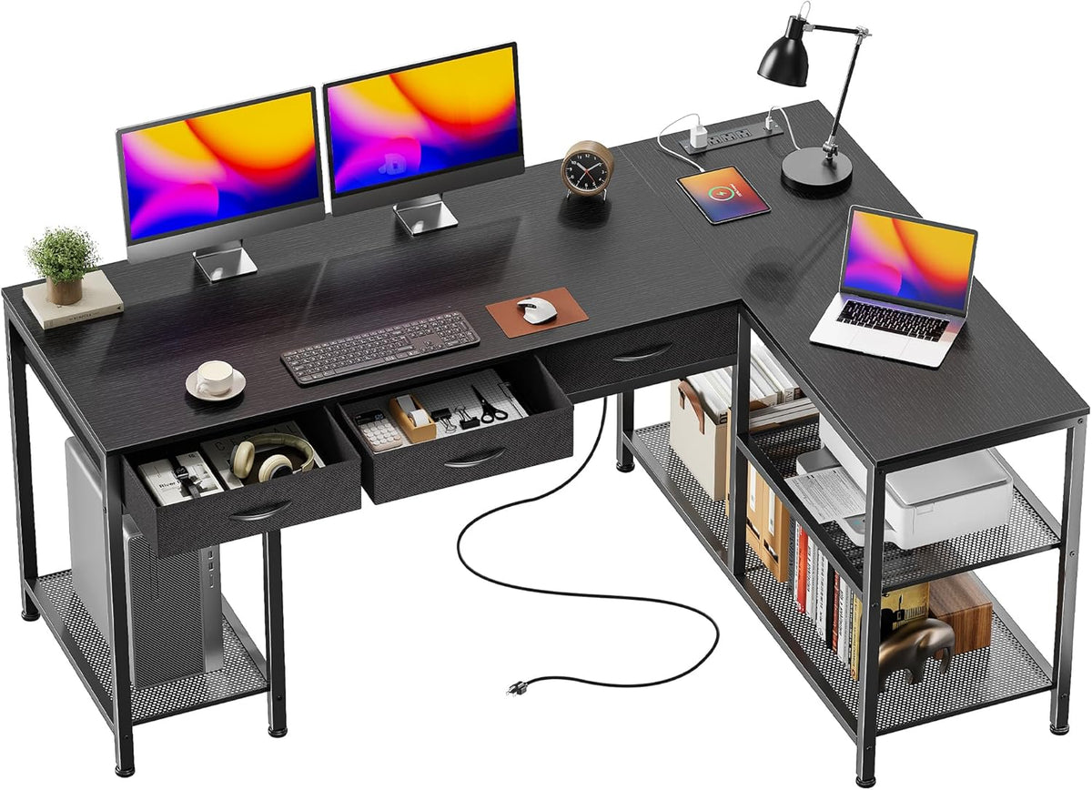 Angled top view of black L-shaped desk showing dual monitors on the main surface and a laptop on the return.