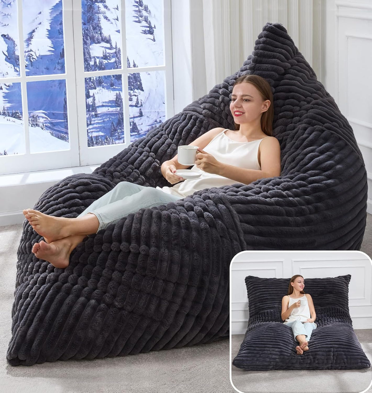 Person reclining on a dark grey bean bag lounger holding a mug with an inset showing the piece flattened into a floor cushion