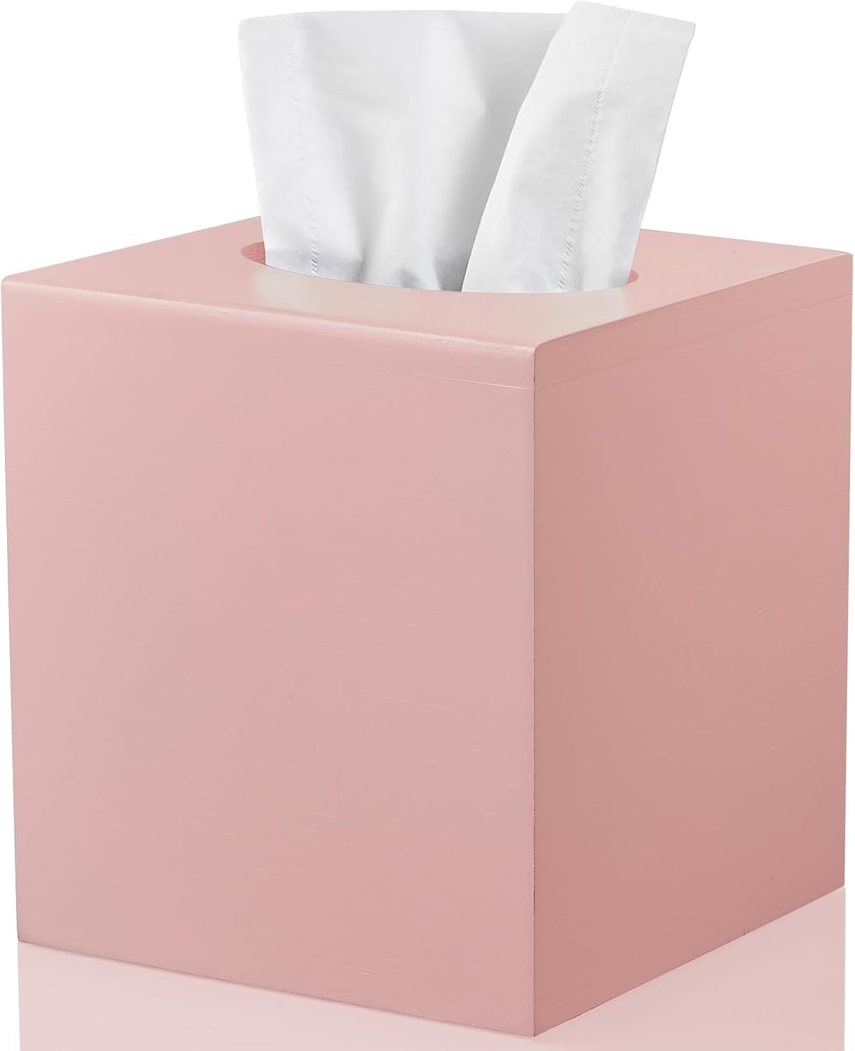 Three-quarter view of a pink painted square tissue box cover with tissues protruding from the top opening.