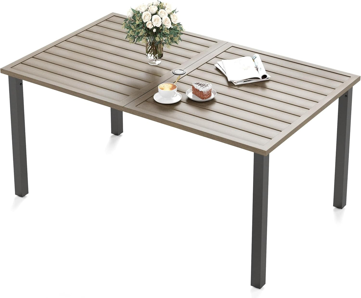 Top-perspective of a rectangular slatted patio table in a light tan finish with dark square legs and tabletop decor.