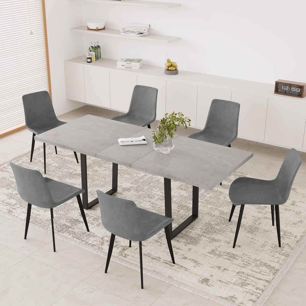 Angled overhead view of gray PU chairs around a concrete-look rectangular table on a patterned rug.