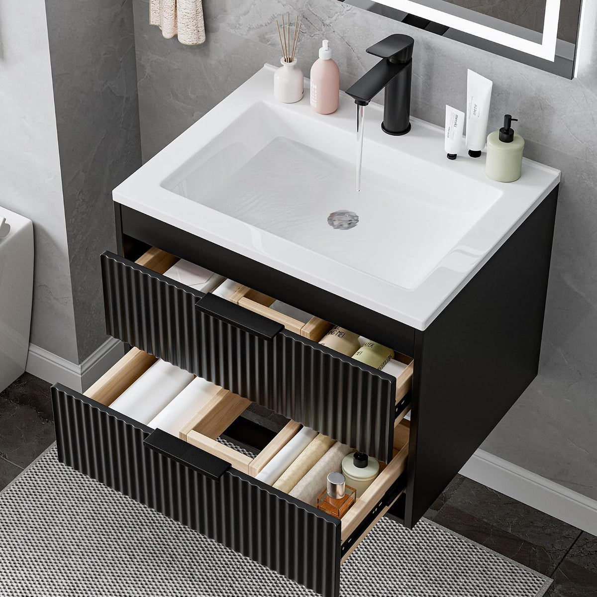 Wall-mounted black vanity with white sink, water running from faucet and both drawers partially open revealing organized