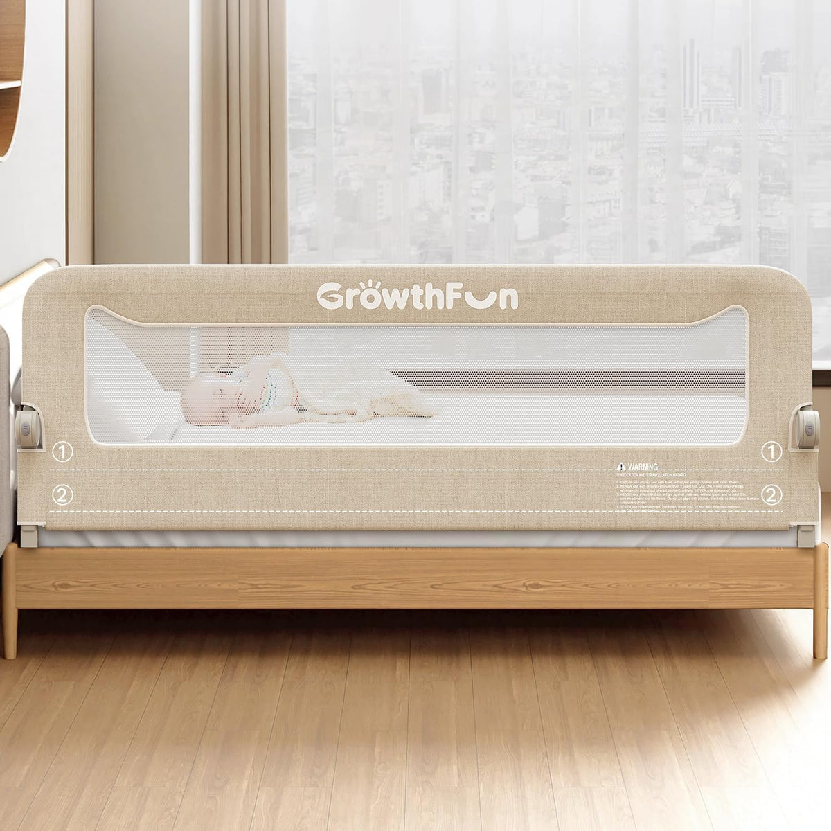 Beige fabric and mesh bed rail mounted on a wooden bed with a small baby visible through the mesh.