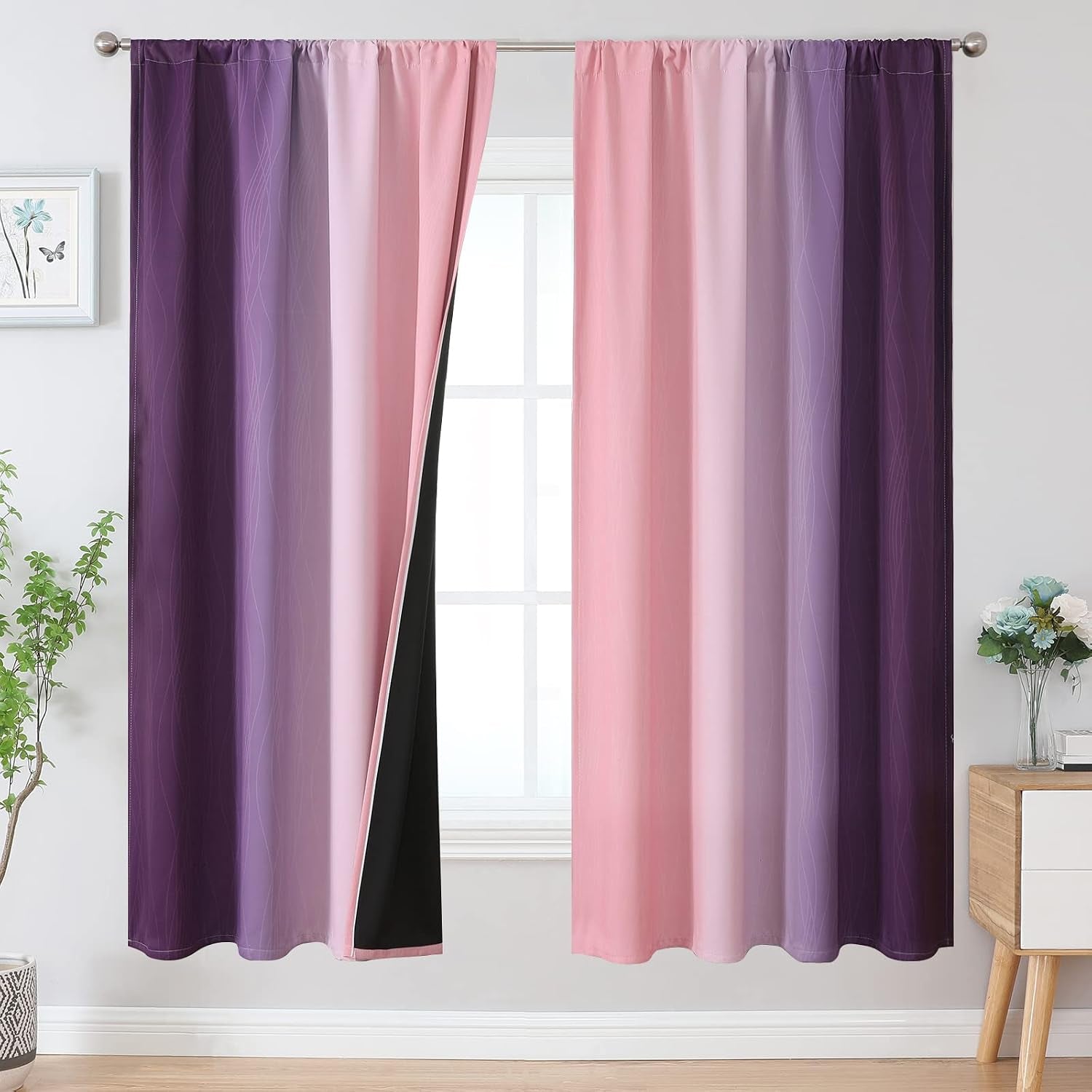 Window with pink-to-purple gradient curtains, wavy line motif and one panel pulled back to reveal the black blackout lining.