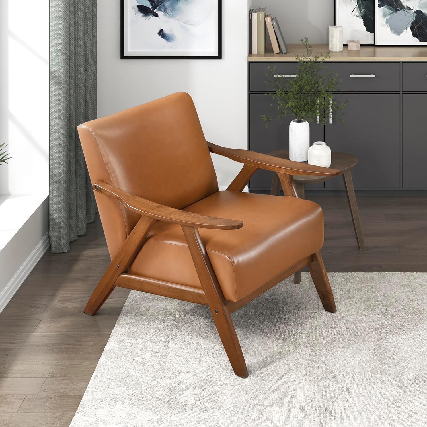 Three-quarter view of the same mid-century chair with darker walnut frame and tan upholstery beside a side table.